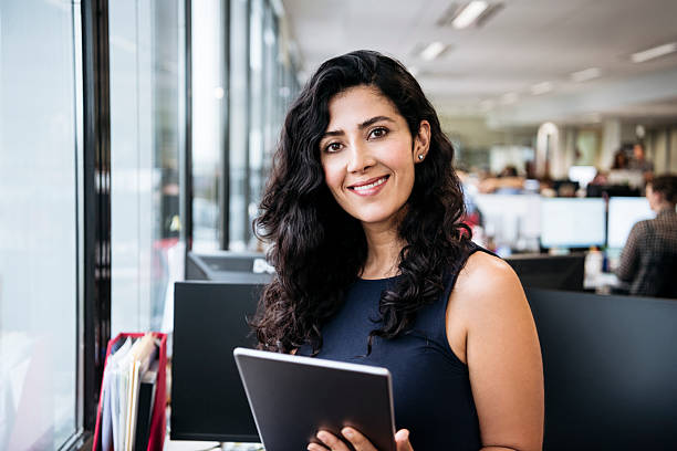 Middle Eastern businesswoman with tablet smiling towards camera