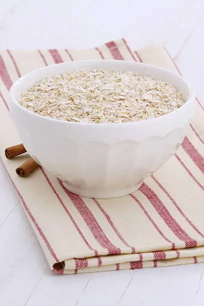 Delicious, nutritious and healthy fresh oats on vintage white wood  setting.