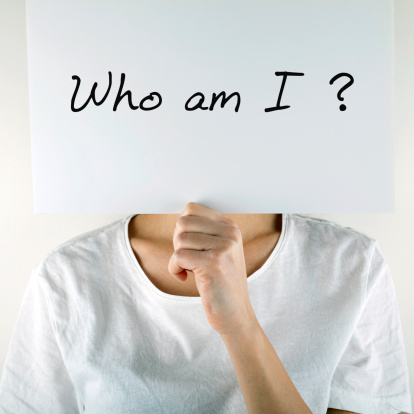 Woman hiding behind placard with ' Who am I? ' question