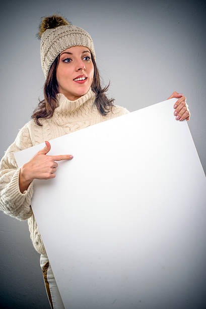 istock Pretty young woman pointing to a blank sign 504338870