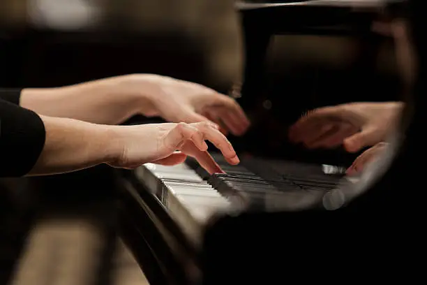 Hands girl playing piano closeup