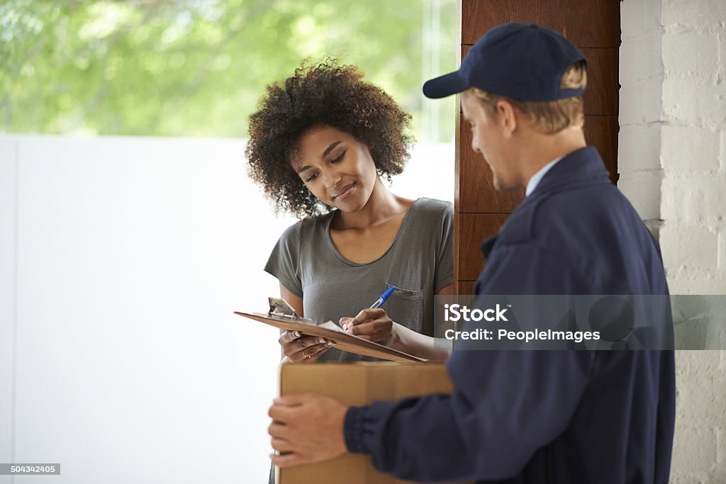 Here's that package you've been waiting for Cropped shot of a young woman signing for a package 20-29 Years Stock Photo