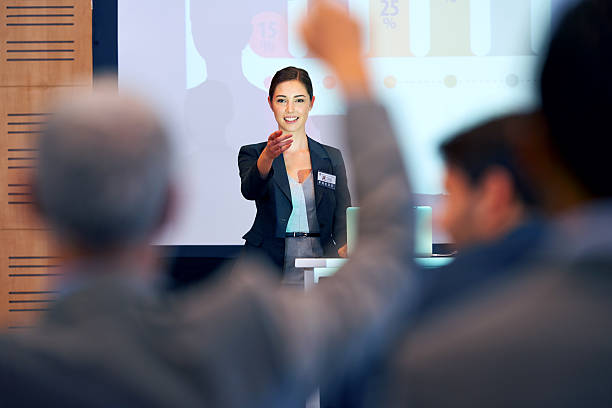 Opening the floor for questions A portrait of a businesswoman gesturing while giving a presentation at a press conference speaker photos stock pictures, royalty-free photos & images