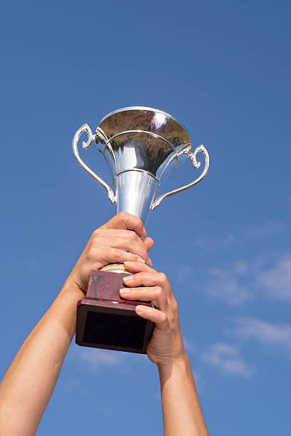 istock Arms raising the winning trophy 504343595