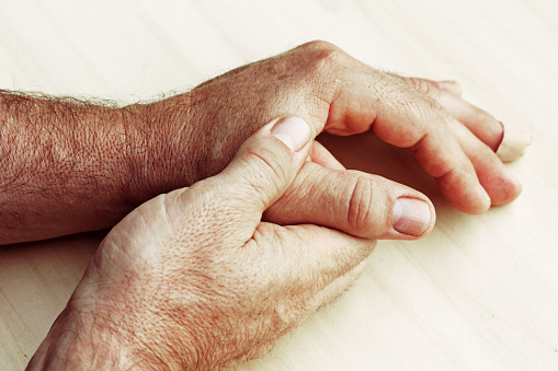 An elderly man has pain in fingers and hands
