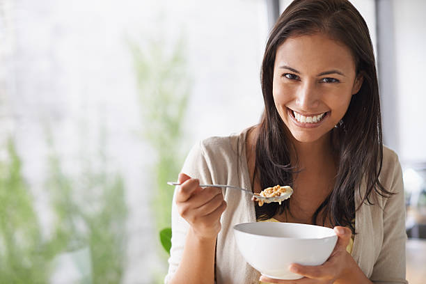 amorevole il gusto fresco dei cereali mattina - eating women breakfast cereal foto e immagini stock