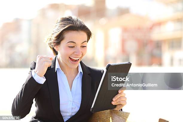 Euphoric Successful Executive Watching A Tablet Stock Photo - Download Image Now - Adult, Adults Only, Business