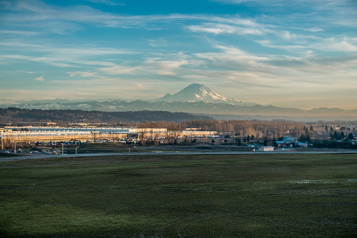 Mount Rainier rises above warehouses in Kent, Washington.