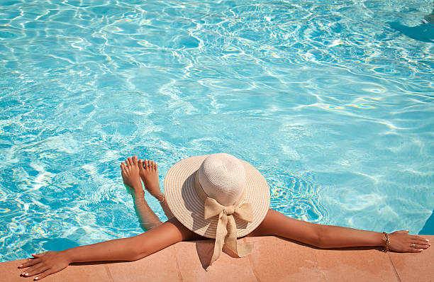 istock Woman in a pool hat relaxing in a blue pool 504371219