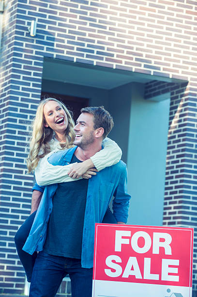 istock Couple standing in front of a new home. 504372300