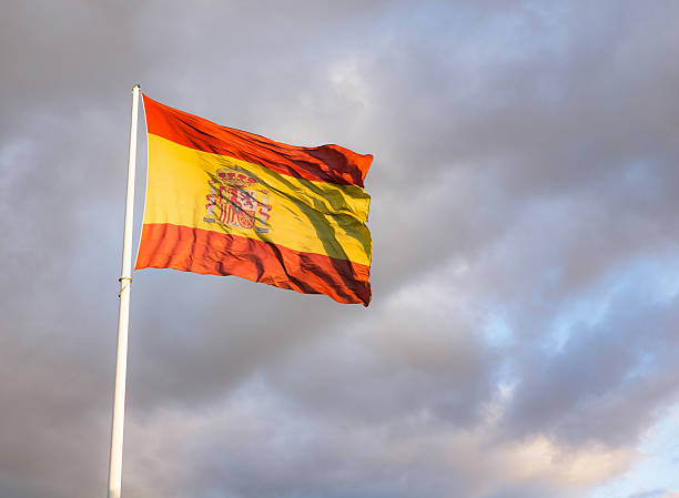 istock Large Spanish flag against overcast sky 504372360