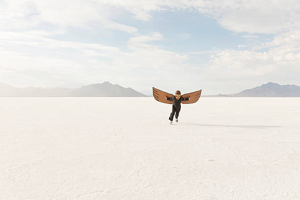 istock Young Business Boy Running with Cardboard Wings 504373554