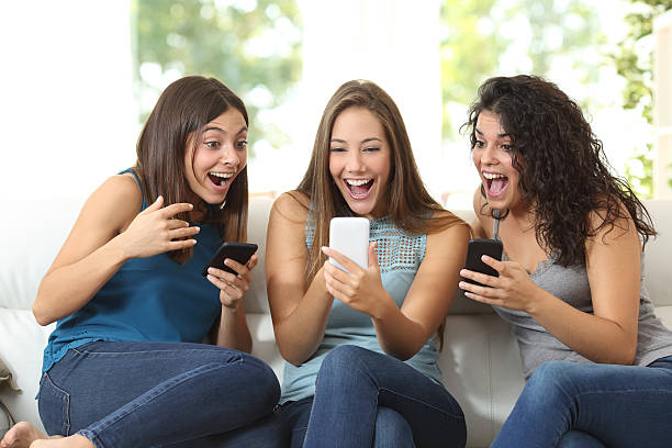 três amigos muito admirado com a vigiar um telefone inteligente - video call imagens e fotografias de stock