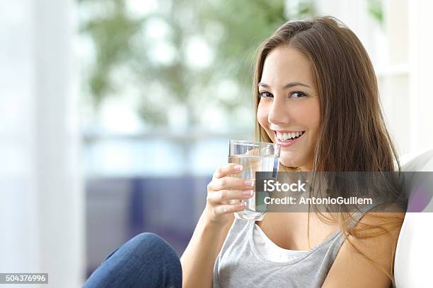 Foto de Garota De Água Potável Em Casa e mais fotos de stock de Água potável - Água potável, Beber, Mulheres