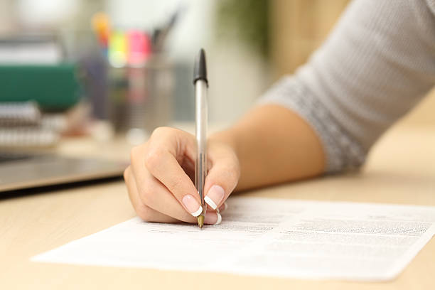 istock Woman hand writing or signing in a document 504377290