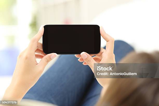 Foto de Mulher Assistindo Meios De Comunicação Social Em Um Smartphone e mais fotos de stock de Smart Phone