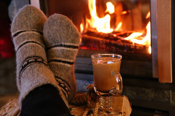 istock Feet in wool socks warming at the fireplace 504378310