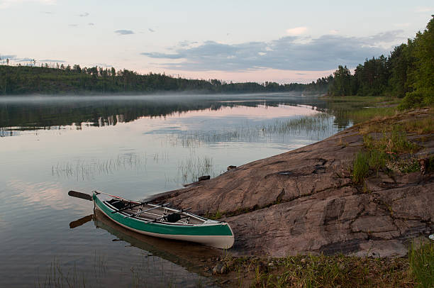 istock Foggy lake with a lone kayak in white night 504379370
