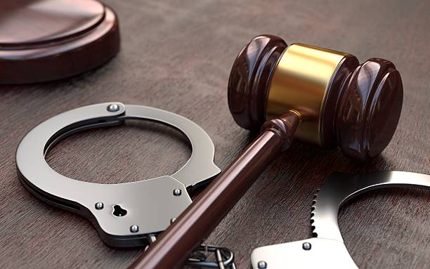 istock Gavel and handcuffs on wooden table background 504380308
