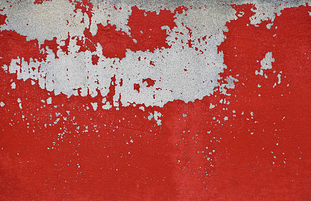 istock Flakes of old red paint on grey concrete wall 504381632