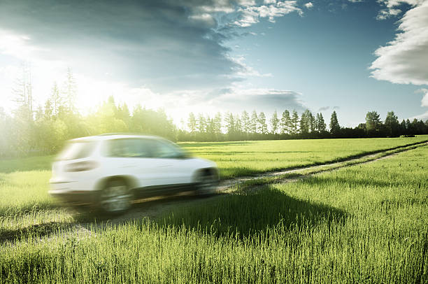 istock spring field and blured car on ground road 504383088