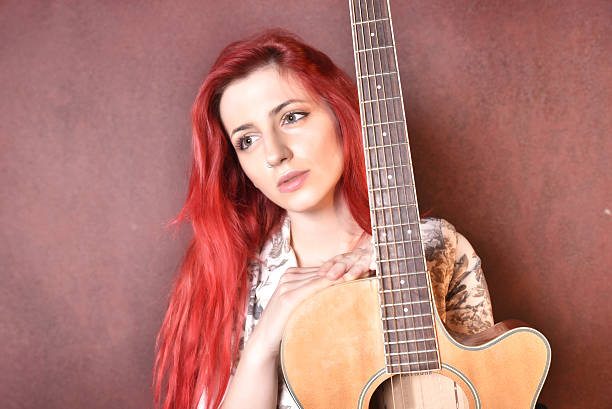istock red-haired girl with a guitar 504387136
