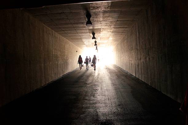 istock People are walking through dark tunnel 504400029