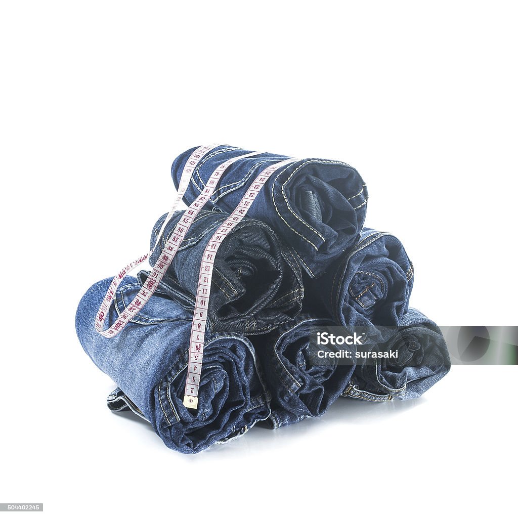Stack of rolled jeans with tape measure Stack of rolled jeans with tape measure isolated on white At The Bottom Of Stock Photo