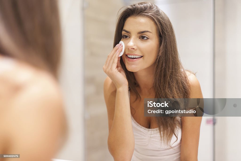 Beautiful brunette woman removing makeup from her face Women Stock Photo