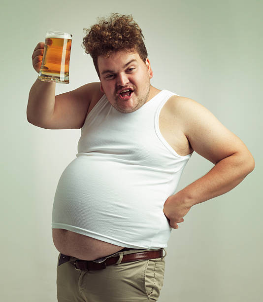 Cheers! Shot of an overweight man raising his beer in toast pot belly stock pictures, royalty-free photos & images