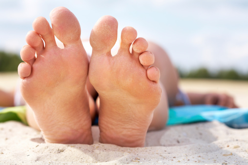 Close-up of a female lying on beach barefoot