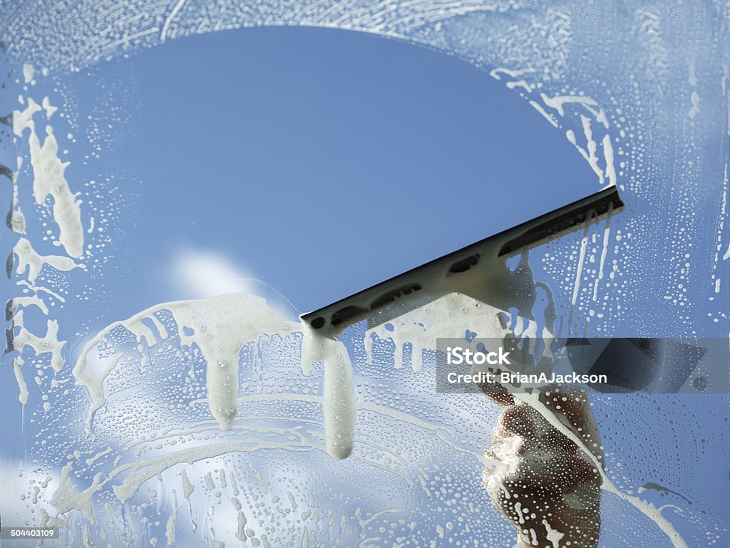 Clear blue sky Window cleaner using a squeegee to wash a window Window Washer Stock Photo