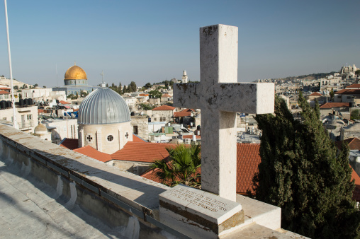 cross on a tombstone with a view of Jerusalem skyline