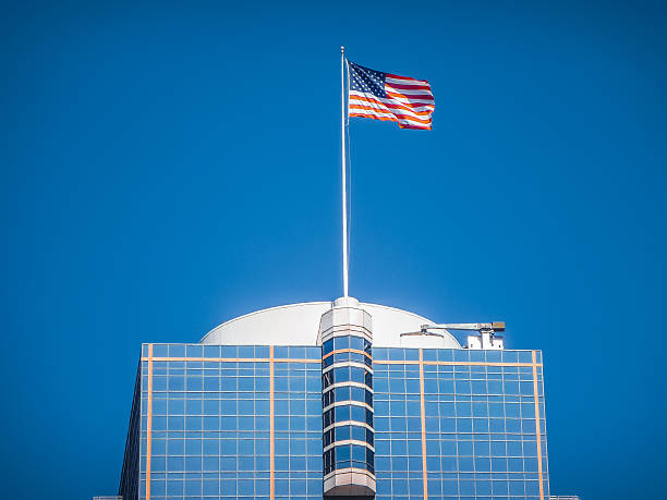 istock American flag waving on top of a modern skyscraper 504416384