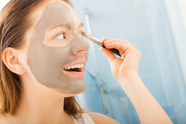 istock Woman applying mud facial mask 504418366