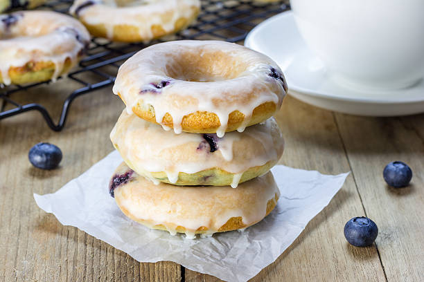 Freshly baked doughnuts with blueberries and lemon glaze, for breakfast stock photo