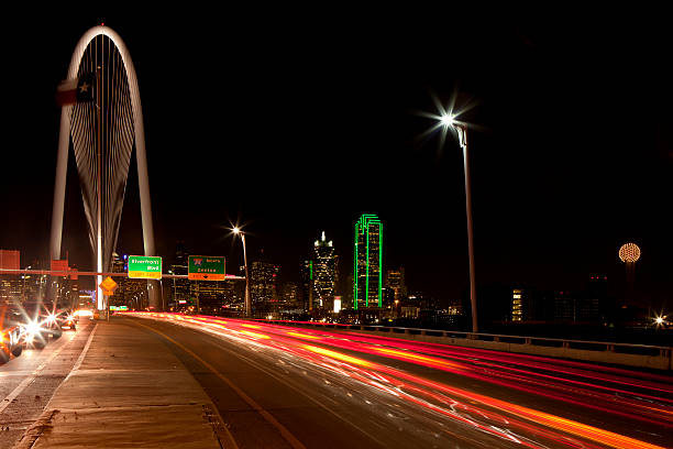 Downtowwn Dallas, Texas at night with the Trinity River in the forground and the new  Margaret Hunt Hill Bridge