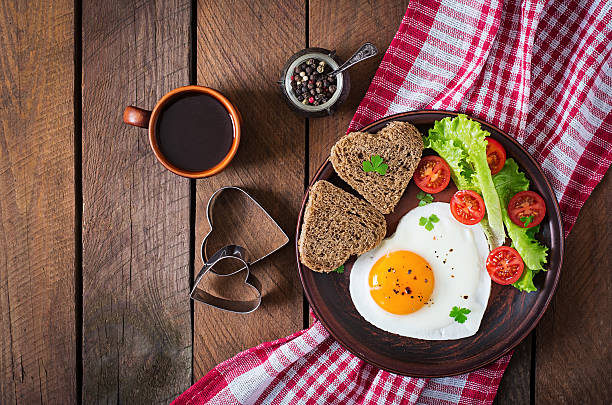 café-da-manhã no dia dos namorados com ovos fritos - eggs breakfast heart shape fried egg - fotografias e filmes do acervo