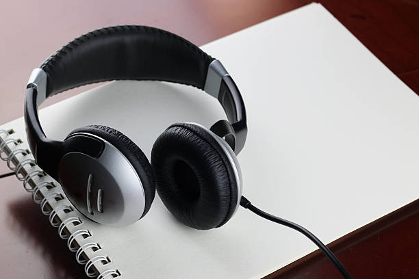 istock Headphones on table next to the tablet and a clock 504428072