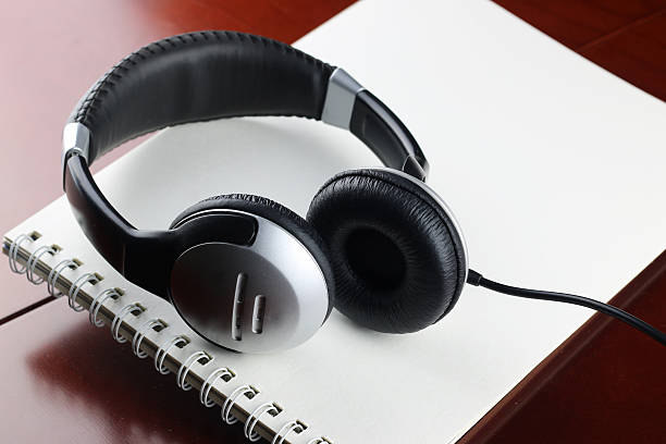 istock Headphones on table next to the tablet and a clock 504428090