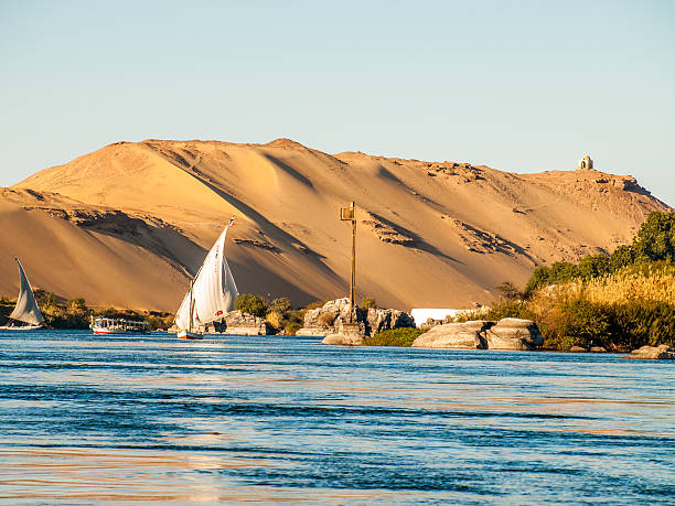 Aswan, Egypt - February 11, 2008: People on board a Felucca boat down the Nile River at Aswan in Egypt. A cruise on a Felucca is a popular activity for tourists visiting Aswan.