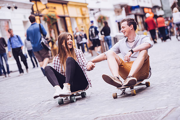 istock Happy young couple sitting on longboards holding hands 504430908