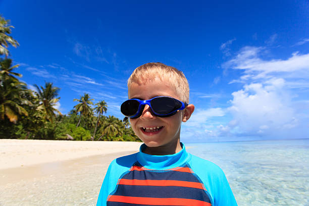istock happy boy in swimming goggles on beach 504443500