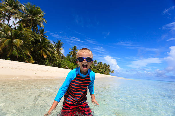 istock happy boy in swimming goggles on beach 504444994