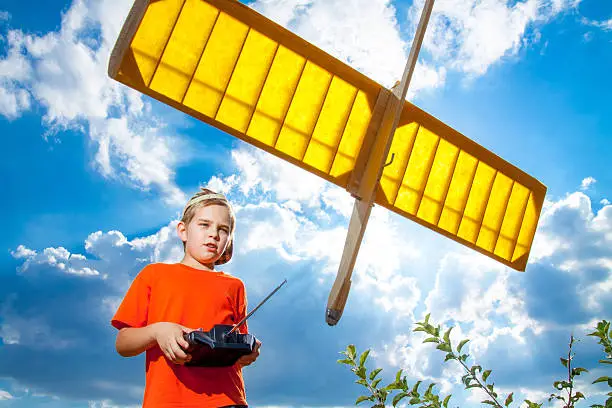 Photo of Little boy playing with handmade RC airplane toy
