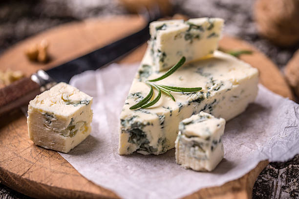 French Roquefort cheese Slice of French Roquefort cheese with walnuts blue cheese stock pictures, royalty-free photos & images