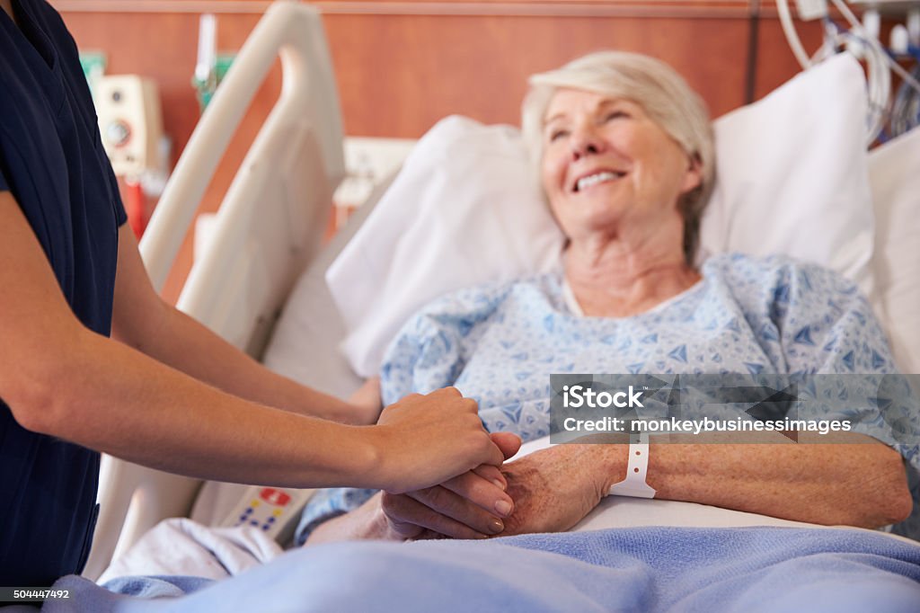 Close Up Of Hospital Nurse Holding Senior Patient's Hand Hospital Stock Photo