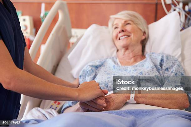 Close Up Of Hospital Nurse Holding Senior Patients Hand Stock Photo - Download Image Now