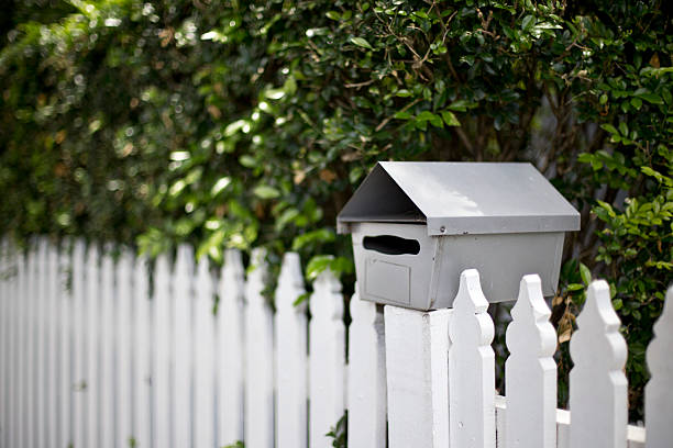 istock White mailbox sitting on a picket fence 504448598