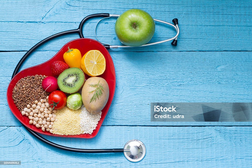 Food on heart plate with stethoscope cardiology concept Food on heart plate with stethoscope cardiology concept on blue boards Doctor Stock Photo